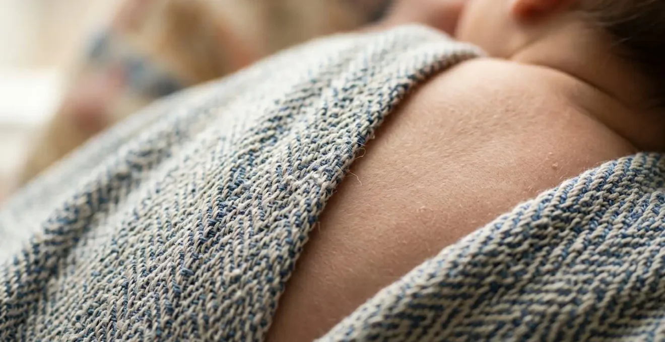 Vue macro détaillée du tissu d'écharpe épousant la courbe naturelle du dos d'un bébé