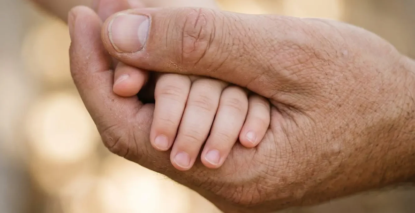 Parent tenant doucement la main d'un enfant, symbolisant l'amour inconditionnel et la sécurité émotionnelle