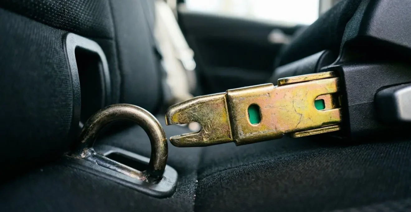 Gros plan sur les crochets métalliques Isofix d'un siège auto moderne avec indicateurs verts visibles dans un véhicule familial