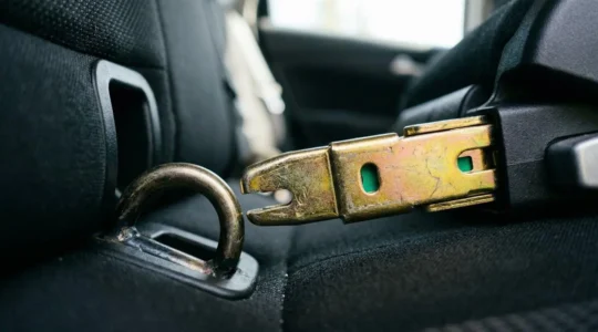 Gros plan sur les crochets métalliques Isofix d'un siège auto moderne avec indicateurs verts visibles dans un véhicule familial