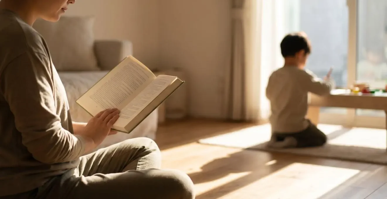 Parent lisant tranquillement un livre près d'un enfant dans un espace calme et apaisant