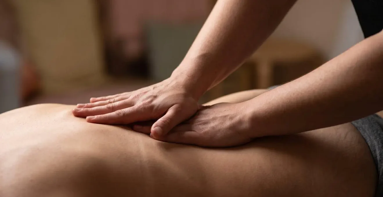 Démonstration de la technique de massage lombaire avec position des mains sur le bas du dos